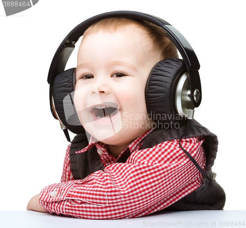 Image of Cute little boy enjoying music using headphones