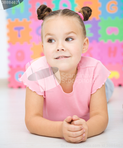 Image of Little girl is laying on floor in preschool