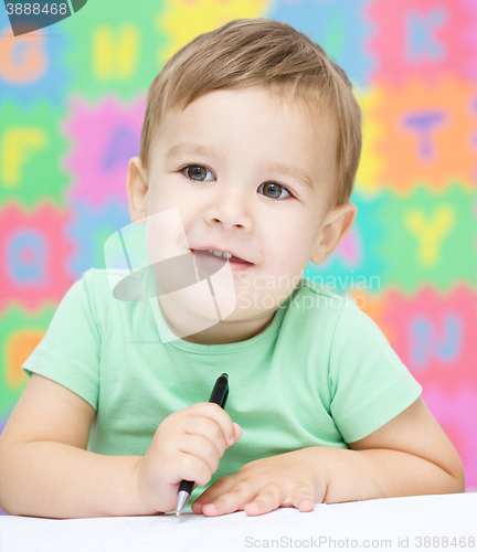 Image of Little boy is writing on his copybook