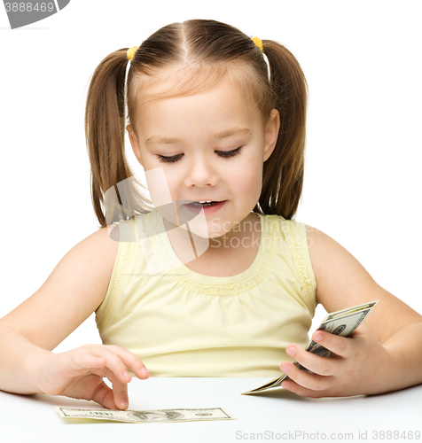 Image of Little girl is counting dollars