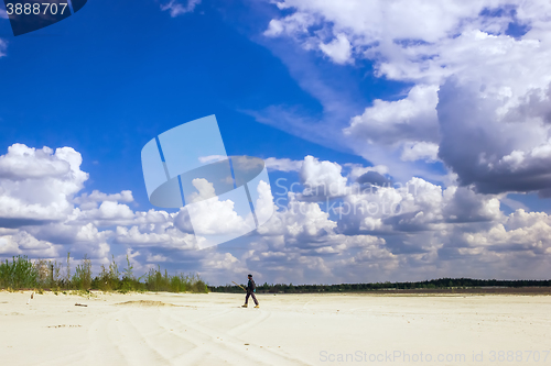 Image of Man in  the turban walking under a cloudy sky