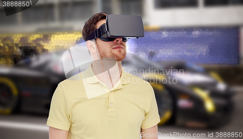 Image of man in virtual reality headset and car racing game