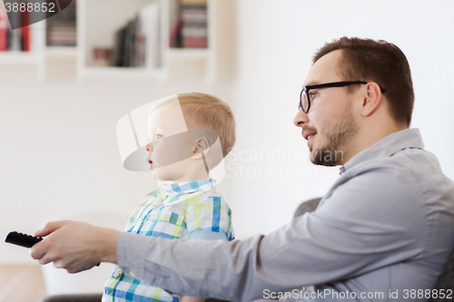 Image of father and son with remote watching tv at home