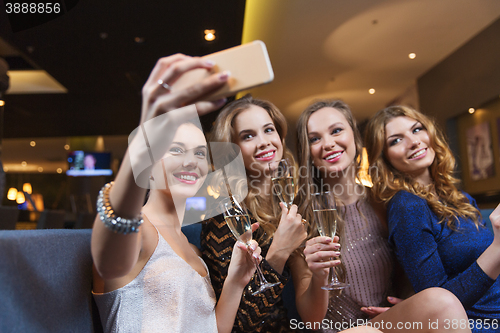 Image of women with champagne taking selfie at night club
