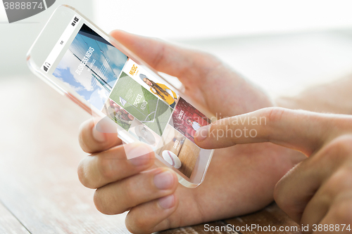 Image of close up of male hand with news on smartphone