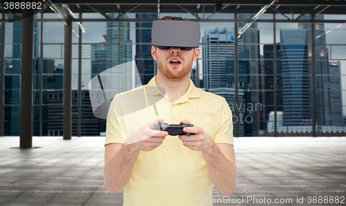 Image of man in virtual reality headset with gamepad