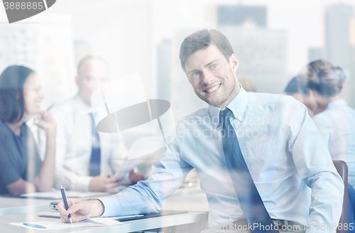 Image of group of smiling businesspeople meeting in office