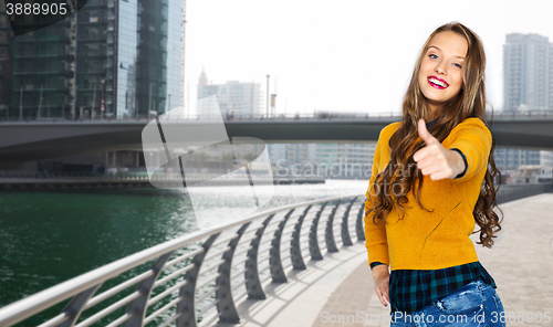 Image of happy young woman or teen girl showing thumbs up