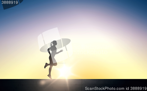 Image of happy young sports woman running outdoors