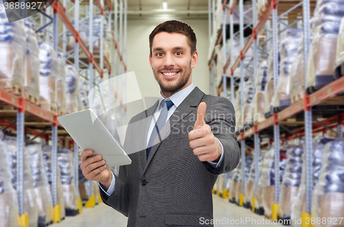 Image of businessman with tablet pc over warehouse