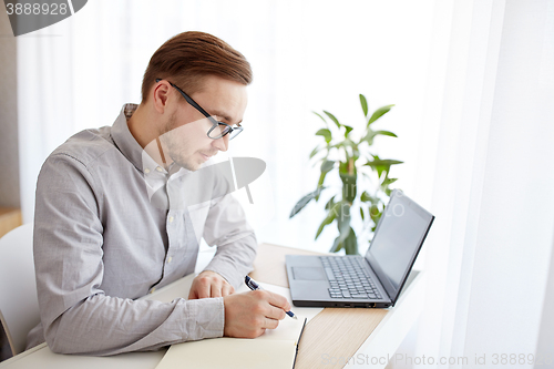 Image of creative man or businessman writing to notebook