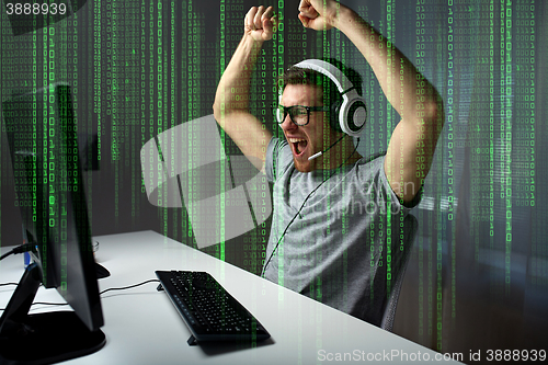 Image of man in headset playing computer video game at home