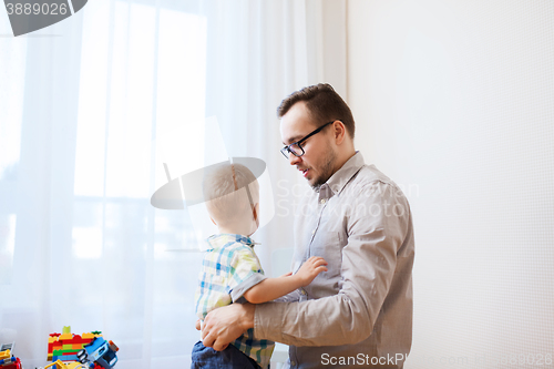 Image of father taking care of little son at home