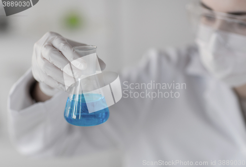 Image of close up of woman with flask making test in lab