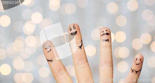 Image of close up of four fingers with smiley faces