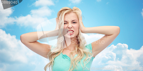 Image of young woman holding to her head and screaming