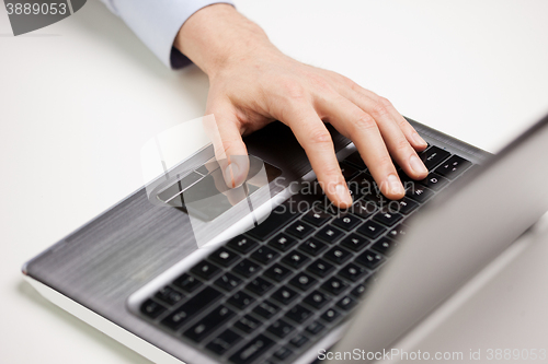 Image of close up of businessman hand typing on laptop