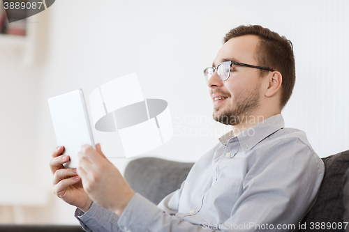 Image of smiling man working with tablet pc at home
