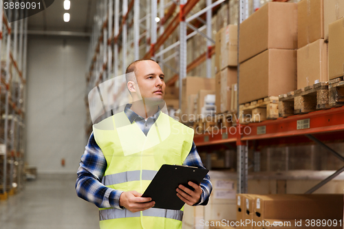 Image of man with clipboard in safety vest at warehouse