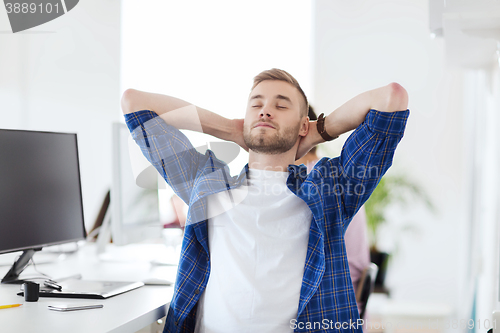 Image of happy creative man with computer at office