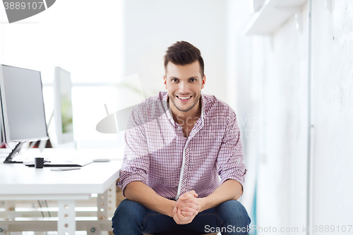 Image of happy creative man with computer at office
