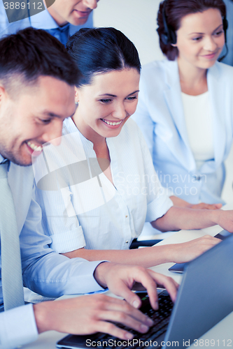 Image of group of people working with laptops in office
