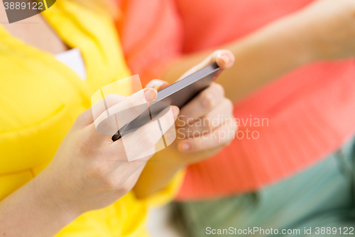 Image of close up of woman texting on smartphone at home