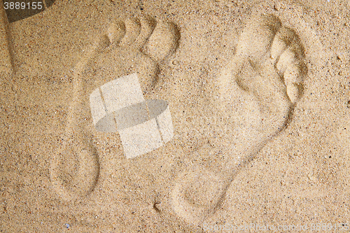 Image of human feet print in the sand