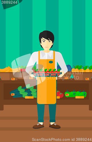 Image of Supermarket worker with box full of apples.
