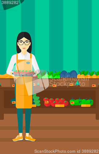 Image of Supermarket worker with box full of apples.