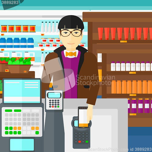 Image of Customer paying with his smartphone using terminal.