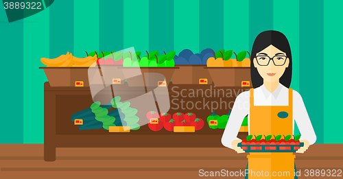 Image of Supermarket worker with box full of apples.