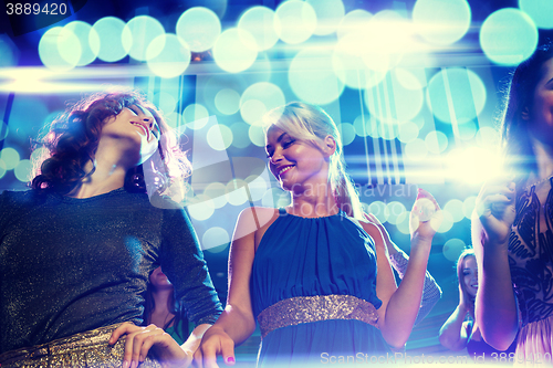 Image of smiling friends dancing in club