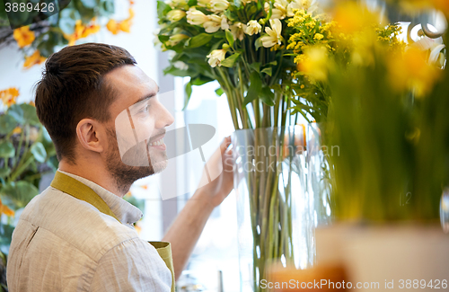 Image of happy smiling florist man at flower shop