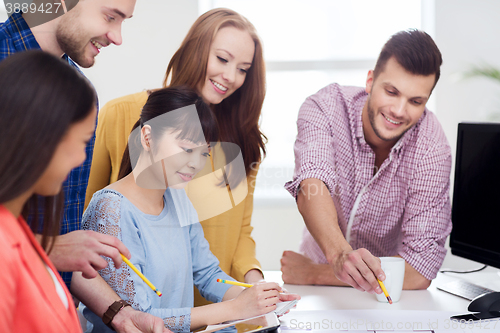 Image of happy creative team or students working at office