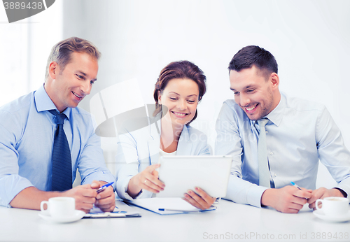 Image of business team looking at tablet pc in office