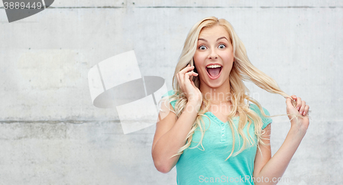 Image of smiling young woman calling on smartphone