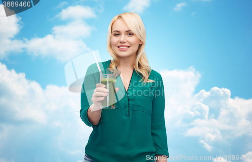 Image of smiling woman drinking vegetable juice or smoothie