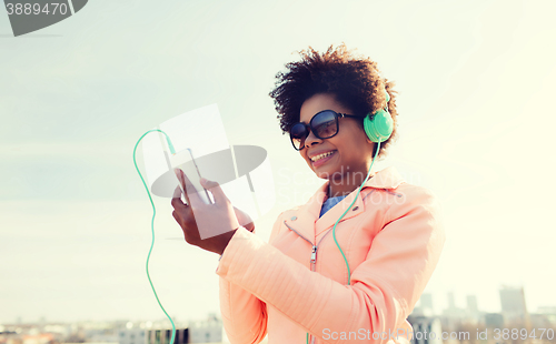 Image of happy young woman with smartphone and headphones