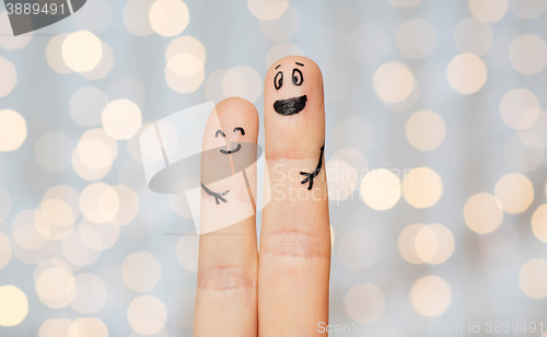 Image of close up of two fingers with smiley faces