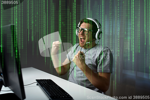 Image of man in headset playing computer video game at home