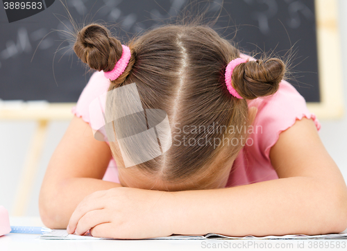 Image of Little girl is sleeping on her writing-book