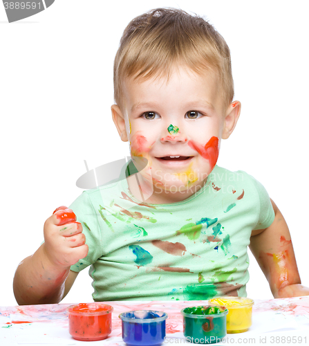 Image of Little boy is playing with paints