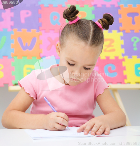 Image of Little girl is writing using a pen