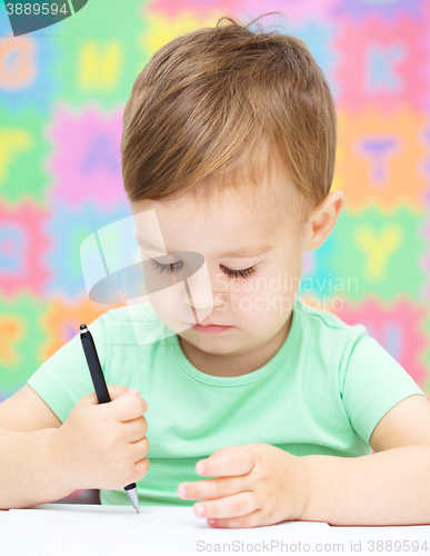 Image of Little boy is writing on his copybook