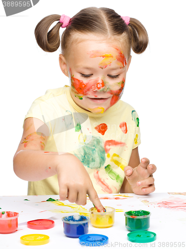 Image of Portrait of a cute girl playing with paints