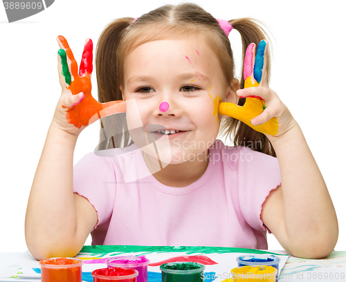 Image of Portrait of a cute girl playing with paints