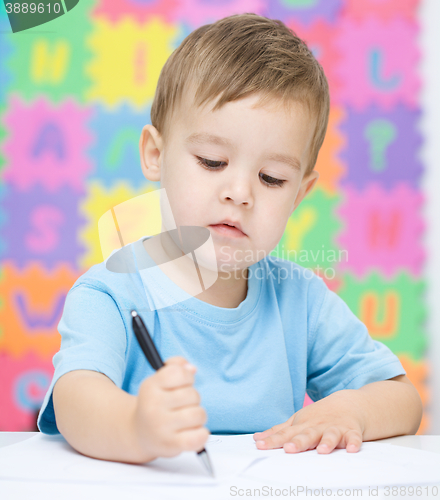 Image of Little boy is writing on his copybook