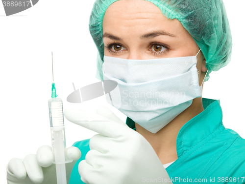 Image of Young nurse is preparing syringe for injection