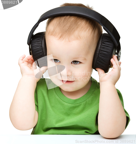 Image of Cute little boy enjoying music using headphones